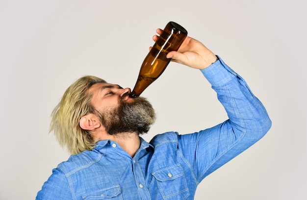 Drunk hipster male craft bottled beer. happy man hold full glass bottle in hand. male holding bottle of beer. hipster rest in pub. Sports lover cheer up. mature man holding glass bottle of beer.