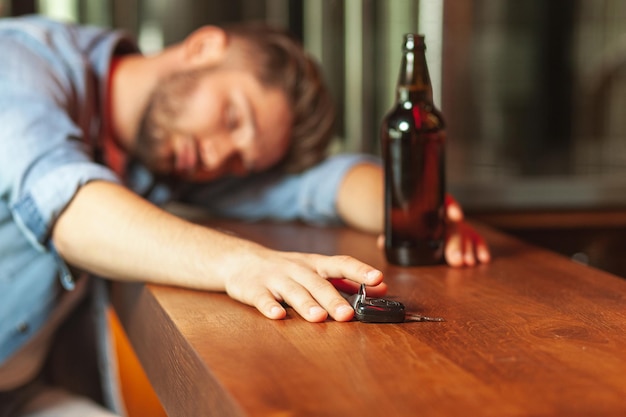 사진 바 카운터에서 자고 차 열쇠를 들고 있는 술취한 남자