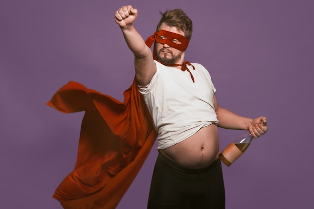 Drunk super antihero holding wine bottle showing his tummy.