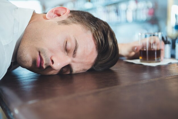 Drunken man sleeping on a bar counter