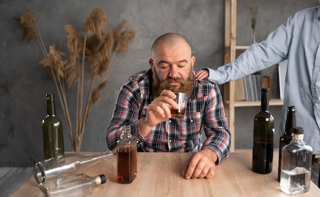 Photo a drunken persons family has a problem with alcohol upset woman put her hand on the mans shoulder concept of support for alcoholics and addiction treatment