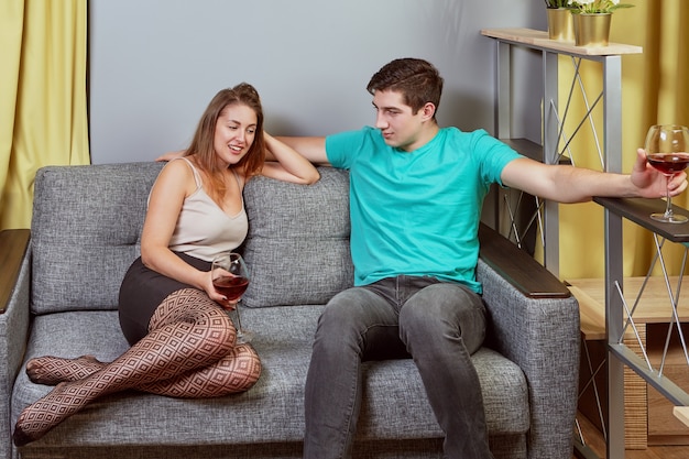 Drunkenness of young couple in student dormitory date with glasses of wine and conversation