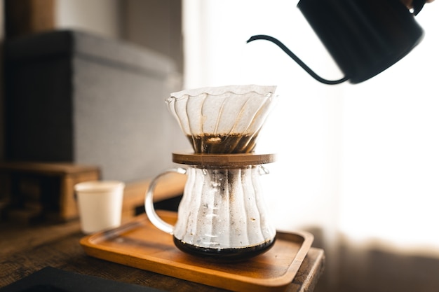 Druppel koffie, barista giet water op koffiedik met filter, koffie zetten