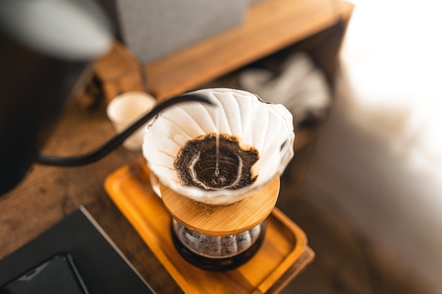 Druppel koffie, barista giet water op koffiedik met filter, koffie zetten