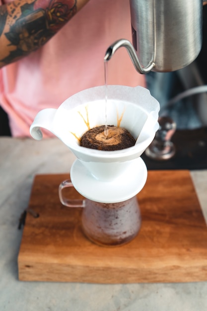 Druppel koffie, barista giet water op koffiemalen met filter, koffie zetten