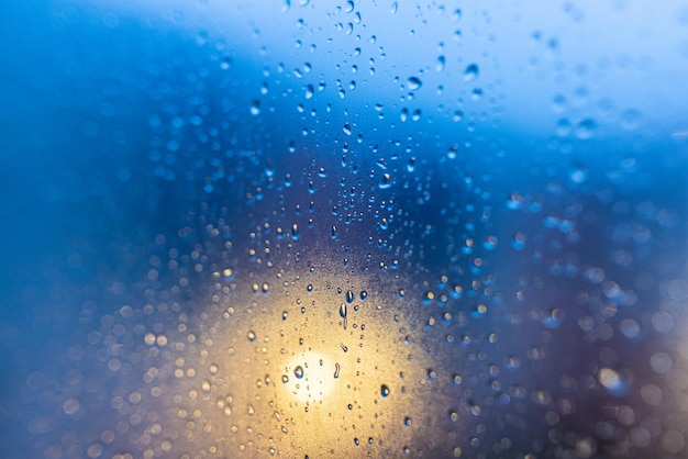 Druppels op glas in het avondlicht