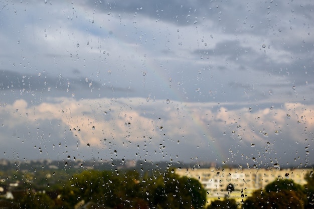 Druppels regen op het raam. Regenachtige dagen in het stadslandschap. onscherp