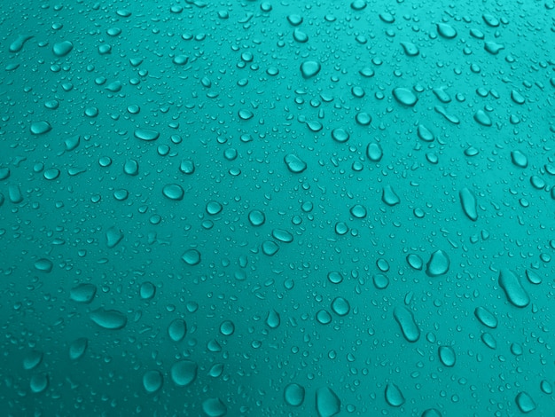 Druppels water op een turquoise metalen oppervlak, mooie achtergrond na regen