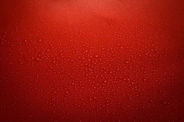 Druppels water op rood en zwart oppervlak. Macro foto, drop, schaduw plastic basis.