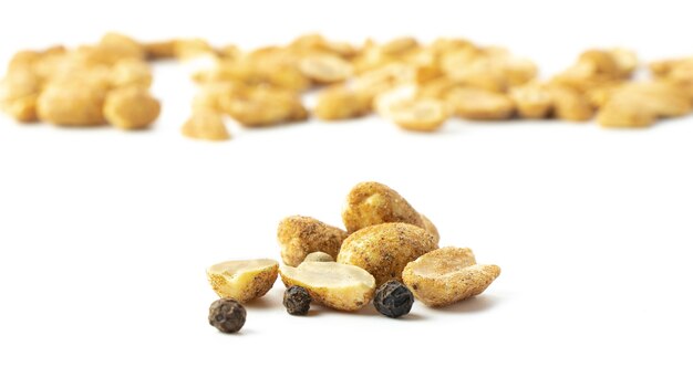 Dry appetizer,
spicy nuts with black pepper in close-up on a white background isolated, copyspace