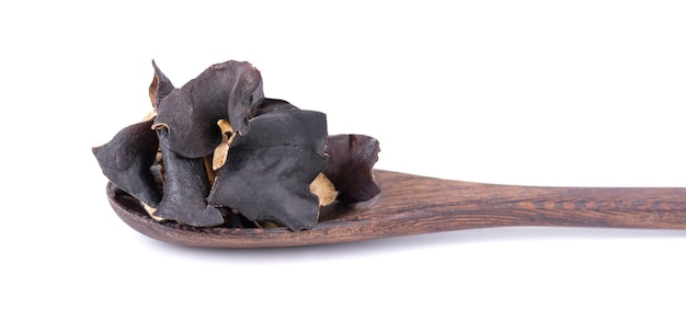 Dry black fungus in wooden spoon isolated on white background Chinese black mushroom or tree black muer mushroom Auricularia polytricha