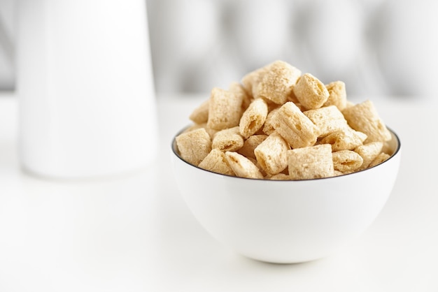 Dry breakfast cereal pads with milk on a light table. selective focus. The concept of healthy, dietary breakfasts.