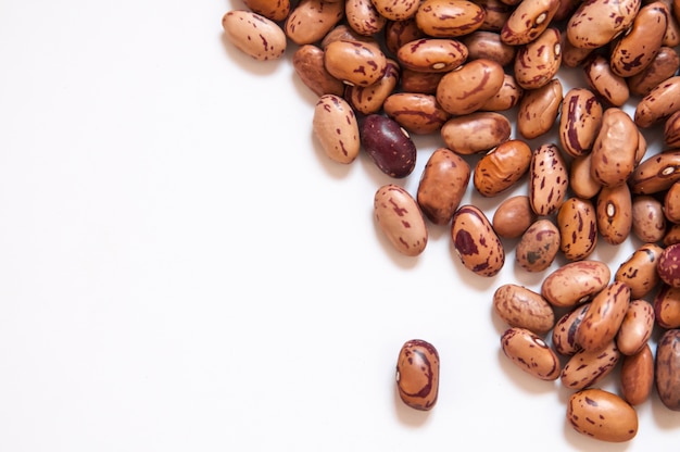 Photo dry brown beans on white background.