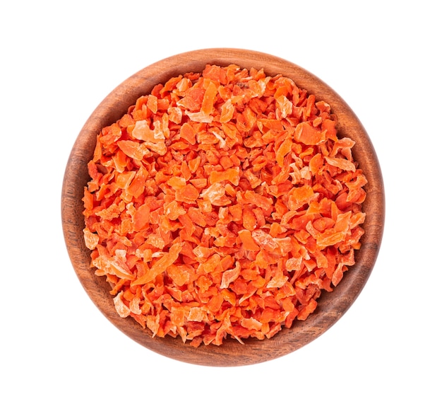 Dry carrot in wooden bowl, isolated on the white background. Chopped dried carrot. Spices and herbs. Top view.