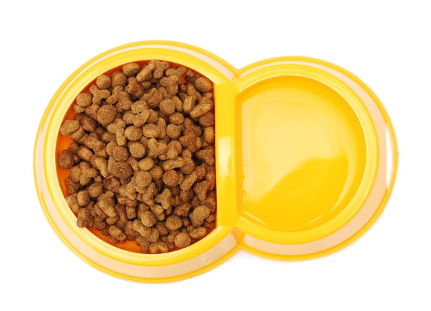 Dry cat food and water in yellow bowl isolated on white