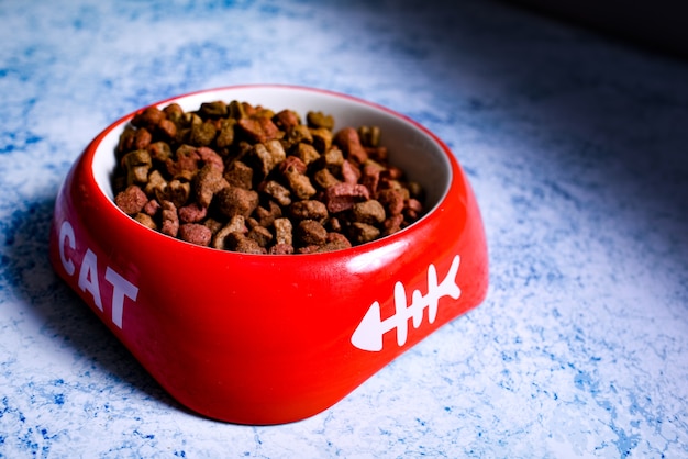 Dry cat kibble in a red bowl