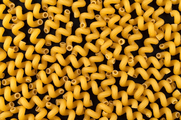 Dry cellentani pasta pattern on black