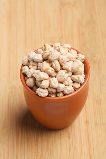 Dry chickpea in bowl on wooden background.