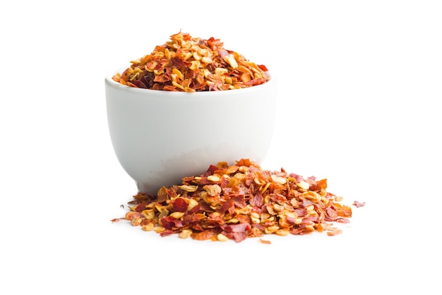 Dry chili pepper flakes in bowl Crushed red peppers isolated on the white background