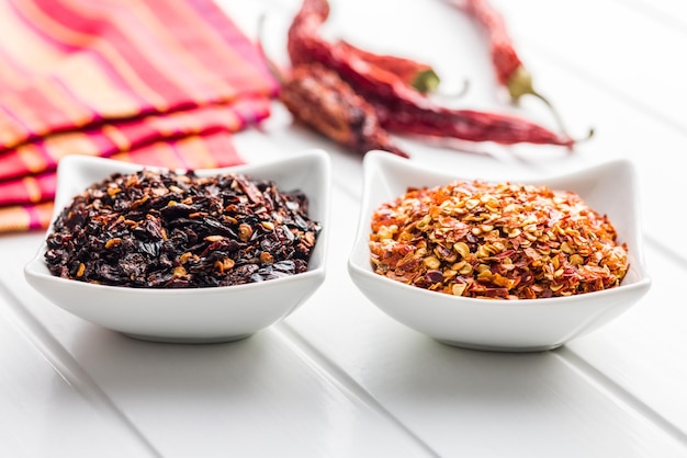 Dry chili pepper flakes Crushed red peppers in bowl on the white table