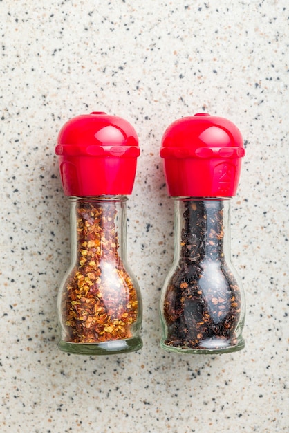 Dry chili pepper flakes Crushed red peppers in mill on the kitchen table Top view