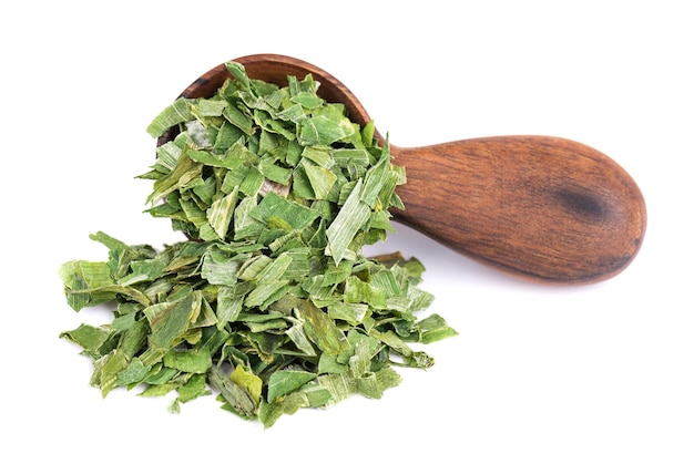 Dry chopped spring onion in wooden spoon isolated on white background Dried green onion or scallion Spices and herbs