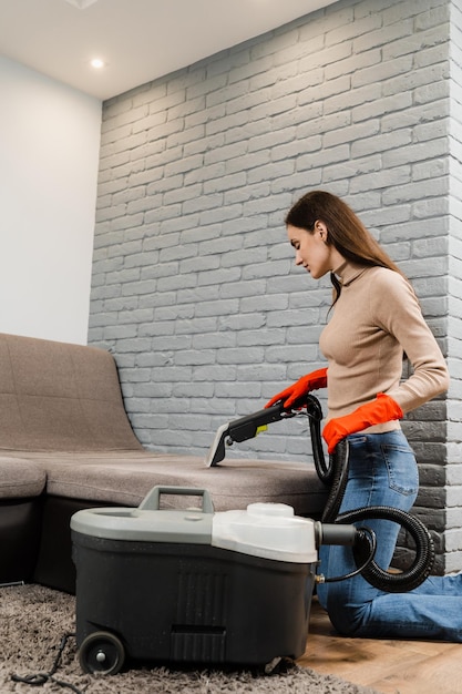 Dry cleaning extractor machine is spraying water and detergent closeup Professional domestic cleaning service worker is removing dirt and dust from couch using dry cleaning machine