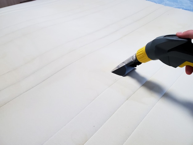 Dry cleaning of the mattress on the bed with professional equipment