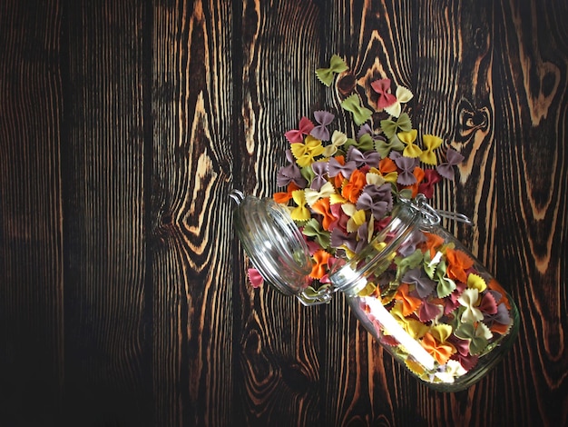 Photo dry colorful italian pasta farfalle or bows with glass jar