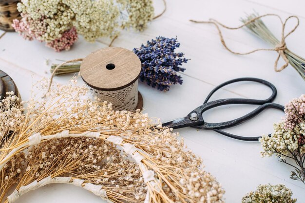 Photo dry compositions and bouquets of flowers and plants for the interior lie on a white wooden table