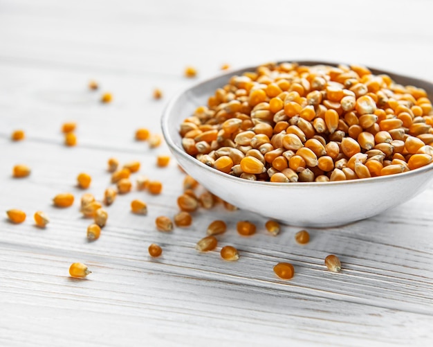 Dry Corn seeds in white bowl on a old wooden  background