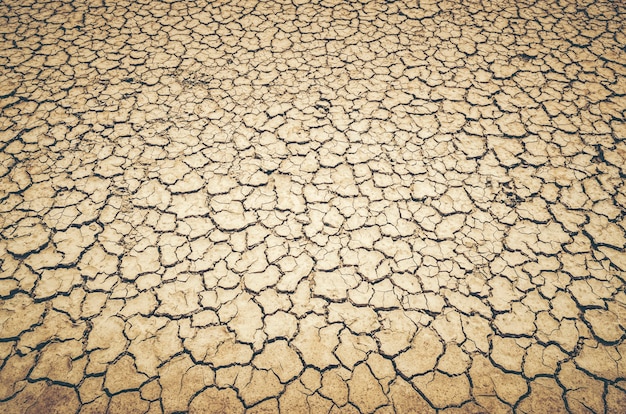 乾いた割れた地球の背景、粘土の砂漠の質感