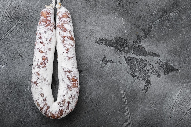 Dry cure salami sausage fuet on grey background, topview with space for text.