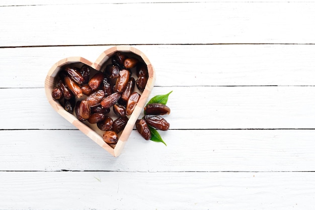 Dry date on a white wooden background. Top view. Free space for your text.