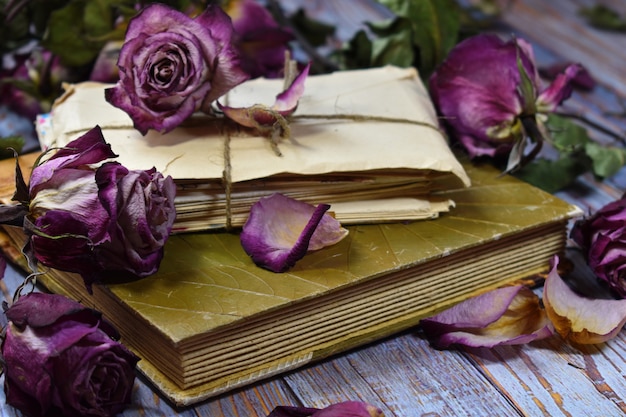 Dry decorative purple rosebuds and old letters