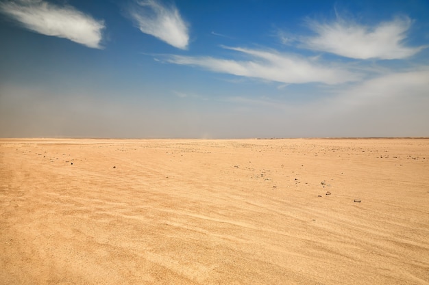 Dry desert landscape. hot lifeless sand of desert and blue sky in summer sunny day