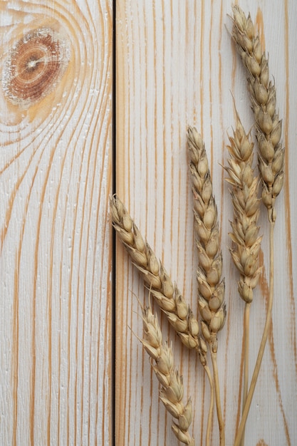 Secchi di spighe di grano su un fondo di legno.