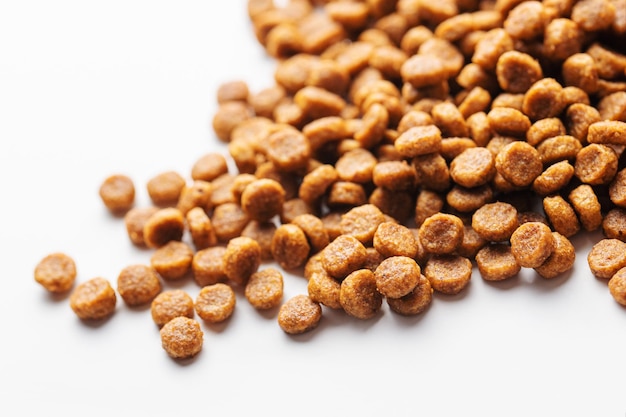 Dry feed pellets for dogs on a white background