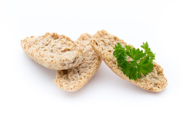 Secco patatine di pane piatto con erbe su uno sfondo bianco.