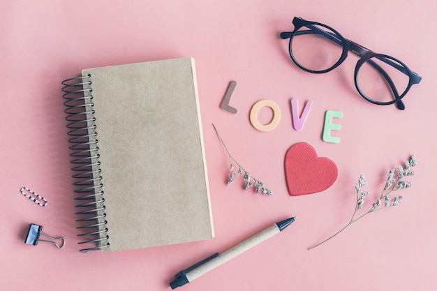 Dry flower with blank notebook on color background