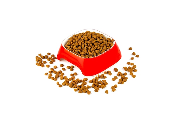 Photo dry food for cats and dogs in a red bowl on a white background.