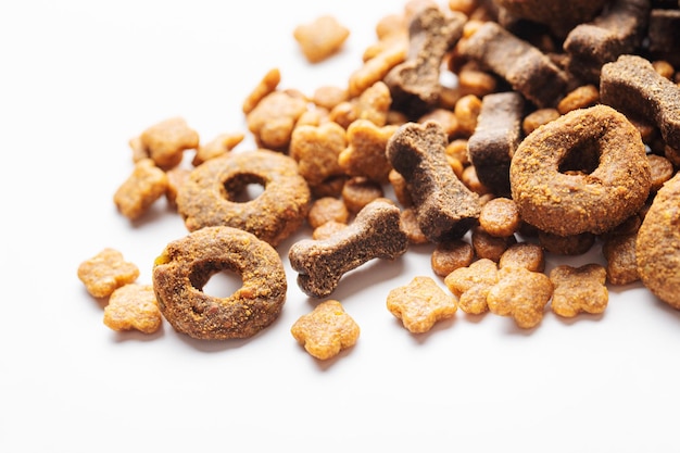 Dry food for dogs of different shapes on a white\
background