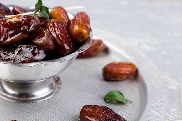 Dry fruit dates on silver tray. copyspace. Close up.