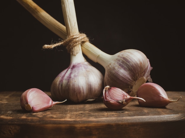 Aglio secco su un tagliere di legno. aglio fresco come mezzo per perdere peso. cibo salutare.