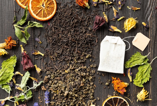 Dry green and black tea tea bag flower tea on a dark background top view closeup