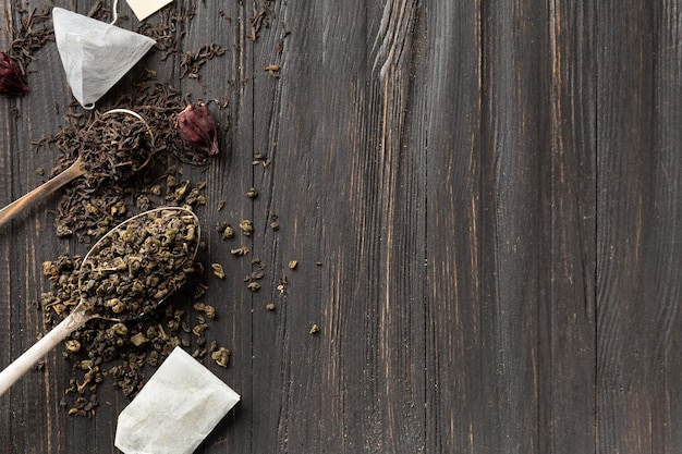 Dry green and black tea tea bags on a dark background top view copy space