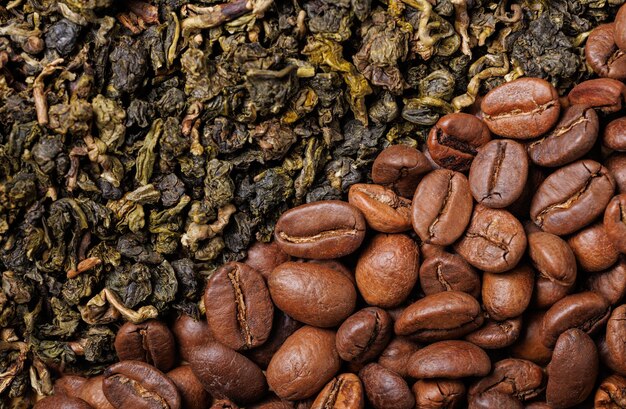 Dry green tea leaves with mango and arabica coffee beans. Diagonal background close-up.