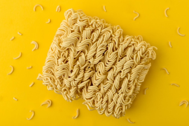 Photo dry instant noodles on yellow background.