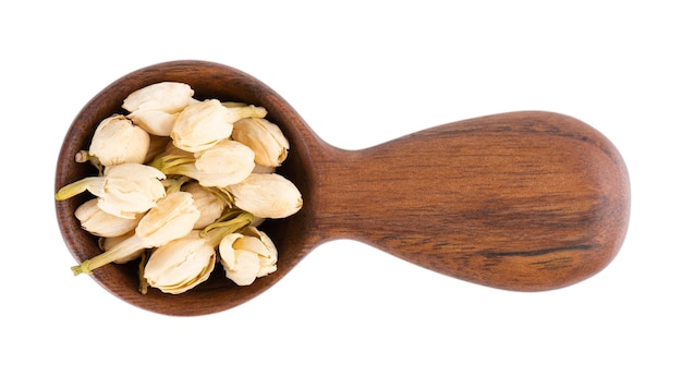 Dry jasmine flowers in wooden spoon isolated on white background Jasmine flowers tea Herbal tea Top view