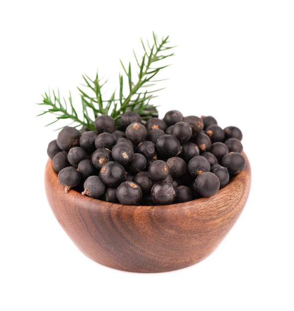 Dry juniper berries in wooden bowl, isolated  . Common Juniper fruits.